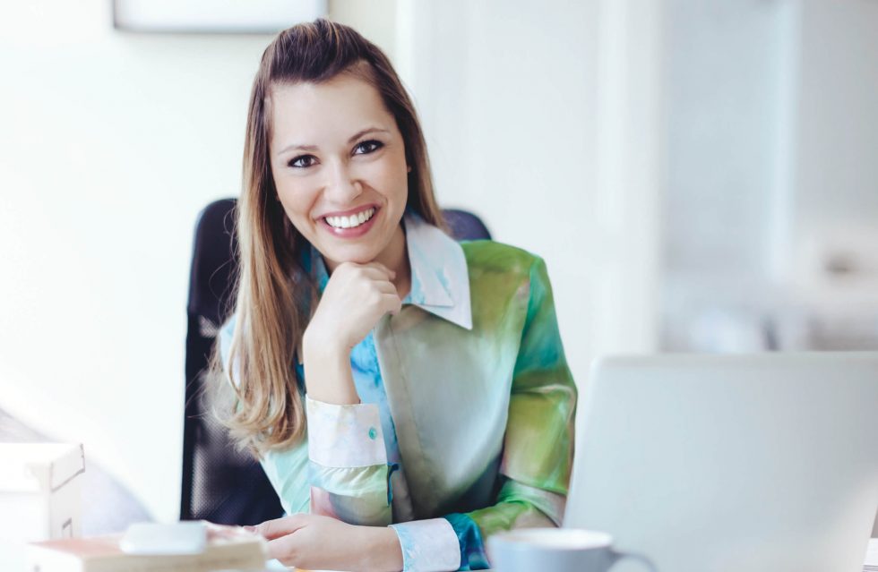 business woman at desk with fist under chin